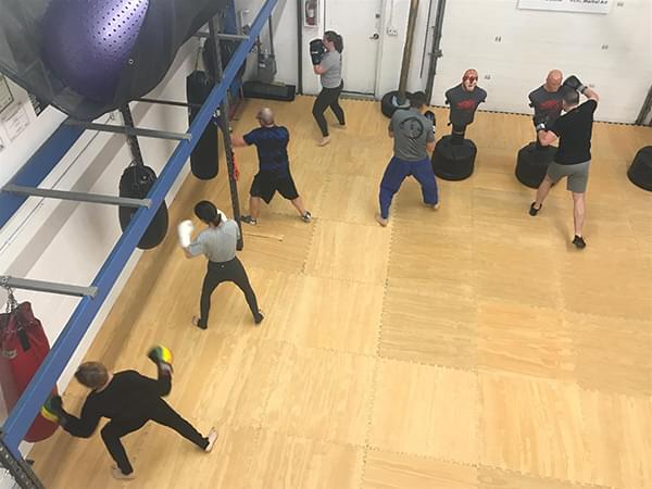 Aerial view of students hitting bags with boxing gloves, kickboxing classes, Wise Warrior Gym in Edmonton